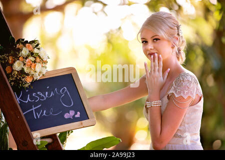 MACKAY, Queensland, Australien - 22. August 2019: Schöne Braut mit einer Tafel mit Küssen, atemberaubende Bild in sanften Schönheit konzentrieren Stockfoto