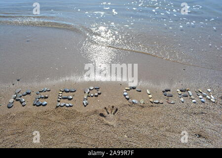 Der Strand und das Meer Verschmutzung Nachricht, halten Sie das Meer und den Strand sauber in Kiesel geschrieben auf einem sauberen Strand mit kristallklarem Wasser Stockfoto