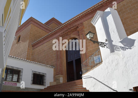 Eingangstür zu einer Kirche in einer Gasse von Andalusischen weiß getünchten Wänden Stockfoto