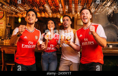 Party aufgeregt Arsenal Fans beobachten Fußball mit Ganzberg Bier in Das Pub Stockfoto