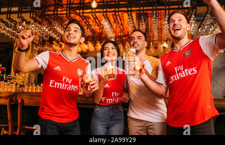 Party aufgeregt Arsenal Fans beobachten Fußball mit Ganzberg Bier in Das Pub Stockfoto