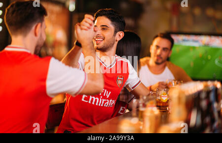 Party aufgeregt Arsenal Fans beobachten Fußball mit Ganzberg Bier in Das Pub Stockfoto