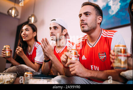 Gerne Freunde oder Arsenal Fans auf Fußball im Fernsehen und Bier trinken Ganzberg Sieg zu Hause feiern. Stockfoto