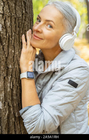 Gerne entspannt weiblichen lehnte sich gegen den Baum Stockfoto