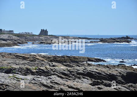 Blick auf die Côte Sauvage auf der Halbinsel Quiberon in der Bretagne, mit dem Turpault im Hintergrund das Schloss Stockfoto