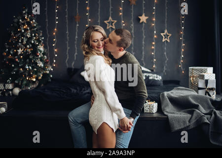 Lächelndes Paar in eingerichtete Zimmer für Weihnachten. Stockfoto