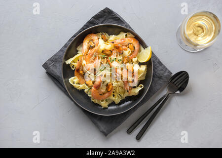 Reginelle Pasta Spaghetti mit Meeresfrüchten, Krabben, Muscheln schwarz Platte am grauen Stein Tabelle, Ansicht von oben. Traditionelles Gericht im Italienischen Restaurant in Mailand, R Stockfoto