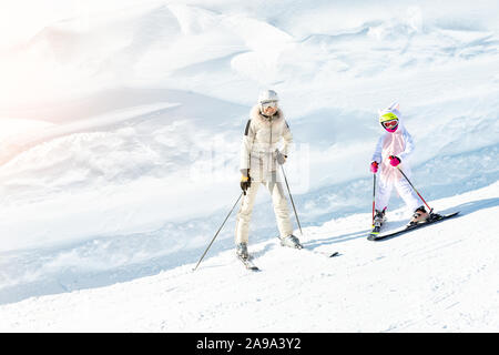 Junge Erwachsene schön sportlich Mutter Spaß Skifahren mit Kind Tochter am Berg alpine Ski Winter Resort. Slim Mamma in Luxus mode Skifahrer geeignet Stockfoto