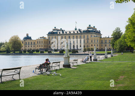 Stockholm Palace, Aussicht im Sommer von Touristen sitzen auf Bänken mit Blick auf Schloss Drottningholm (drottningholms Slott) - Auf der Insel Lovön, Schweden. Stockfoto