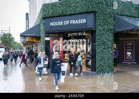 Pre-Christmas Käufer außerhalb des House of Fraser Haupteingang auf der Oxford Street, London, UK Stockfoto