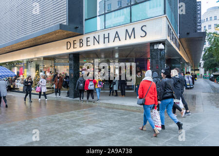 Pre-Christmas Käufer außerhalb Debenhams Haupteingang auf der Oxford Street, London, UK Stockfoto