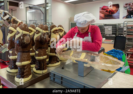 Schmalkalden, Deutschland. 08 Nov, 2019. 08.11.2019, Thüringen, Schmalkalden: Konditor Bernadette Weber Pressen weiße Schokolade in eine schokoladenform für Weihnachtsmänner. Der 32-jährige Kunsthandwerk eine Sonderausgabe für das Weihnachtsgeschäft von viba Süßwaren GmbH, vier Kilogramm Weihnachtsmänner. Quelle: Stephan Schulz/dpa-Zentralbild/ZB/dpa/Alamy leben Nachrichten Stockfoto