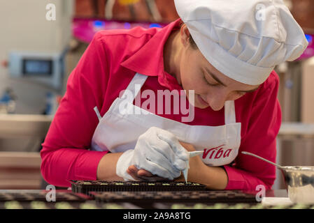 Schmalkalden, Deutschland. 08 Nov, 2019. 08.11.2019, Thüringen, Schmalkalden: Konditor Heather Rebhuhn schmückt kleine Pfefferminz Pralinen in der Nougat Welt in Schmalkalden. Die 26-Jährige kommt aus Australien. Kam sie nach Deutschland für die Liebe. Für das Weihnachtsgeschäft von viba Süßwaren GmbH, sie macht Schokolade und Weihnachtsmänner von Hand. Wie das Unternehmen mitteilte, produziert jährlich 600.000 Weihnachtsmänner. Die kleinste Santa Claus wiegt 10 g, die größte 4 kg. Quelle: Stephan Schulz/dpa-Zentralbild/ZB/dpa/Alamy leben Nachrichten Stockfoto