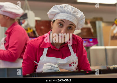 Schmalkalden, Deutschland. 08 Nov, 2019. 08.11.2019, Thüringen, Schmalkalden: Konditor Heather Rebhuhn schmückt kleine Pfefferminz Pralinen in der Nougat Welt in Schmalkalden. Die 26-Jährige kommt aus Australien. Kam sie nach Deutschland für die Liebe. Für das Weihnachtsgeschäft von viba Süßwaren GmbH, sie macht Schokolade und Weihnachtsmänner von Hand. Wie das Unternehmen mitteilte, produziert jährlich 600.000 Weihnachtsmänner. Die kleinste Santa Claus wiegt 10 g, die größte 4 kg. Quelle: Stephan Schulz/dpa-Zentralbild/ZB/dpa/Alamy leben Nachrichten Stockfoto