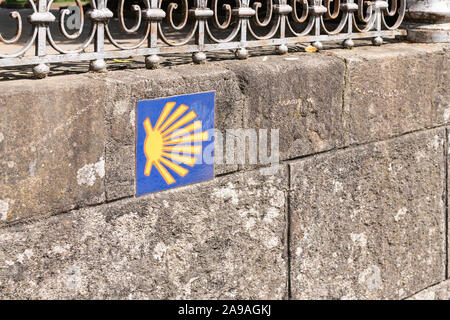 Camino de Santiago schild Kachel auf der Steinmauer. Jakobsweg weg Shell. Stadt Santiago de Compostela, Spanien Stockfoto