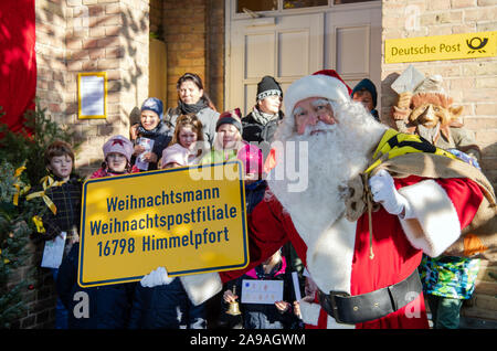 Himmelpfort, Deutschland. 14 Nov, 2019. Santa Claus ist mit einem Schild vor den Kindern der Klasse 2 a der Grundschule Fürstenberg Drei gesehen mit der Aufschrift anta Claus-weihnachtspostfiliale - 16803 Himmelpfort", der Adresse für die Weihnachtspost, vor dem Weihnachtspostamt. Bis Weihnachten Santa Claus will Briefe von Kindern aus der ganzen Welt gemeinsam zu beantworten Mit einigen Helfern von hier. Bisher über 6000 Briefe bei der Post angekommen. Credit: Soeren Stache/dpa-Zentralbild/dpa/Alamy leben Nachrichten Stockfoto