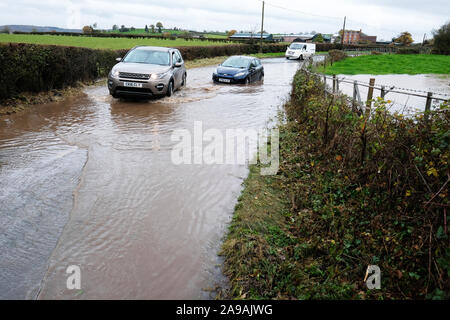 Bodenham, Herefordshire, UK - Am Donnerstag, den 14. November 2019 - Autofahrer in 4WD Fahrzeuge einen kleinen blauen Ford Fiesta Auto in tiefem Wasser auf einer Landstraße in der Nähe des Dorfes Bodenham klemmt nach weiteren Regen auf bereits gesättigten Bereichen fiel. Foto Steven Mai/Alamy leben Nachrichten Stockfoto