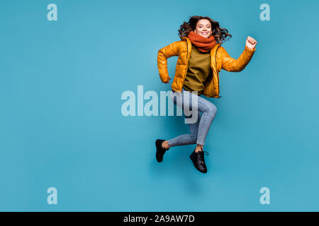 Voller Körper Foto von erstaunlichen Dame springen hoch laufen schnell einkaufen rabatte aufgeregt Verschleiß stilvolle windbreaker Jeans schal Pullover isoliert Blau Stockfoto