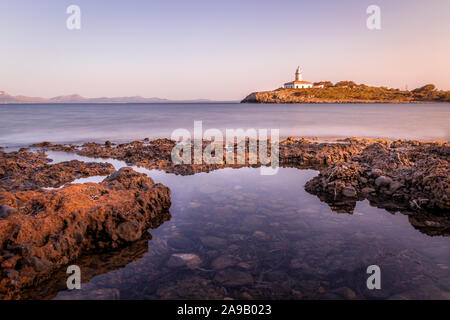 Alcudia Leuchtturm (Faro de Alcanada) in der Nähe von Alcudia Strand (Playa de Alcudia) und Alcudia. Kleine Insel mit Felsen im Meer und beaut Stockfoto