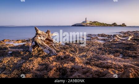 Alcudia Leuchtturm (Faro de Alcanada) in der Nähe von Alcudia Strand (Playa de Alcudia) und Alcudia. Kleine Insel mit Felsen im Meer und beaut Stockfoto