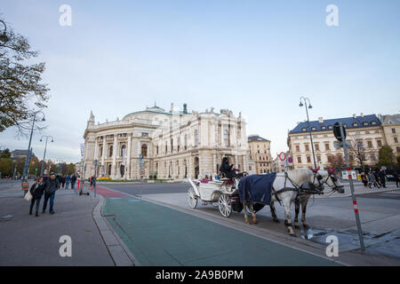 Wien, ÖSTERREICH - NOVEMBER 6, 2019: Fiaker, einem typischen Pferdekutsche, vor dem Burgtheater stehend, eines der wichtigsten Theater in Wien ein Stockfoto