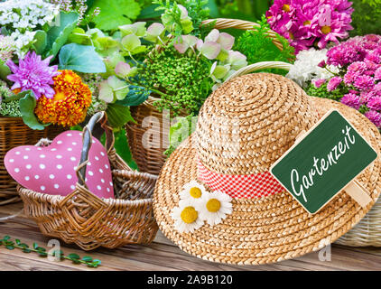 Blumen mit Strohhut und Herz label deutsche Garten Zeit Stockfoto