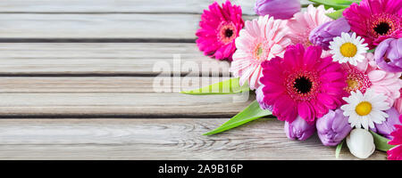 Blumenstrauß gegen Holzbrett Stockfoto