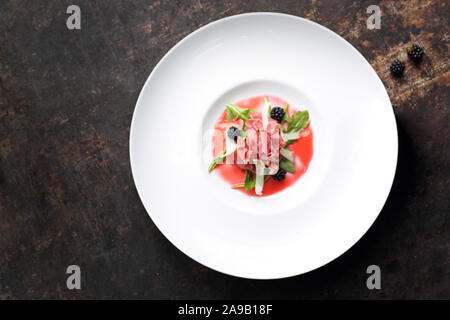 Carpaccio vom Rind, serviert auf Himbeere und Blackberry Mousse. Vorspeise Stockfoto