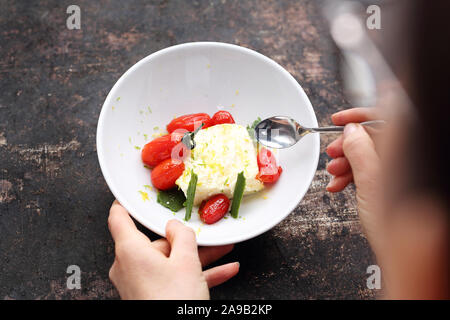 Frau isst Eis. Hausgemachte Lemon Ice Cream mit karamellisierten Tomaten. Stockfoto
