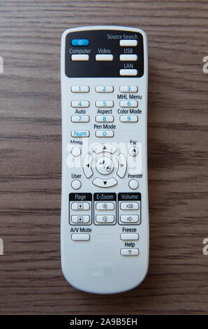 Remote Controller. Weiße Projektor System Fernbedienung Holz- Hintergrund. Projektor Konsole auf einem Holztisch. Stockfoto