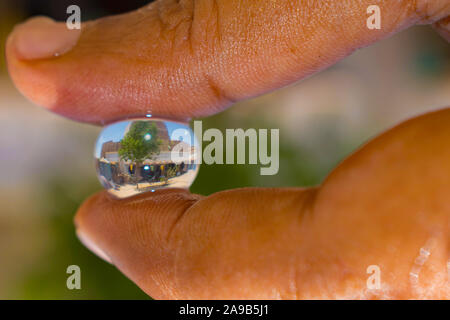 Reflexion in einem Haus in einer Hydro gel Ball. Ein Haus in ein Hydro Ball mit grünem Hintergrund verschwommen. Stockfoto