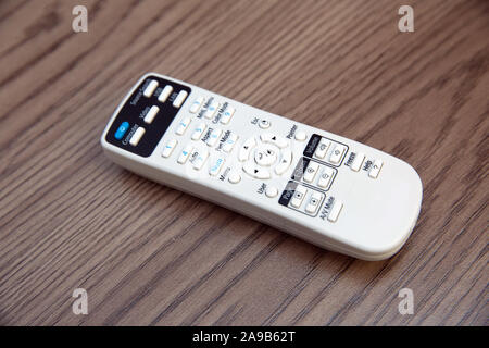 Remote Controller. Weiße Projektor System Fernbedienung Holz- Hintergrund. Projektor Konsole auf einem Holztisch. Stockfoto