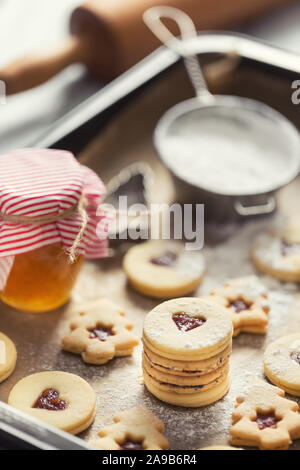 Weihnachten linzer Süßigkeiten und Plätzchen marmelade Zucker Pulver in gebackenen Pan. Stockfoto