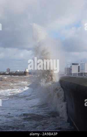 Gezeiten und schwere Stürme die Promenade Peitschen in New Brighton auf dem Wirral, Großbritannien mit Sea Spray krachend gegen den Küstenschutz Stockfoto