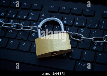 Computer Tastatur durch ein Metall Kette und Schloss gesichert. Konzept Foto von Cyberkriminalität und Internet und Computer Sicherheit und Sicherheit. Stockfoto