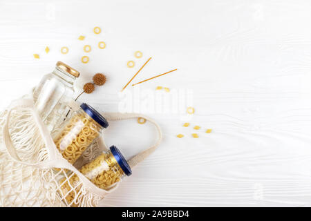 Pasta und eine Flasche Wasser im Netzbeutel. Null Abfall Konzept, einfache Leben Stil. Stockfoto