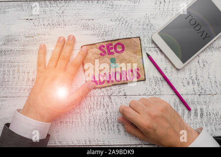 Text Zeichen zeigen, Seo und Adwords. Business Foto text Bezahlung pro Klicken Sie auf das digitale Marketing Google Adsense Hand halten beachten Sie Papier in der Nähe der Ausrüstung und Schreiben Stockfoto