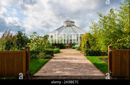 Achteckige Glasshouse in das globale Wachstum Gemüsegarten im RHS Hyde Hall. Stockfoto