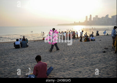 12.12.2011, Mumbai, Maharashtra, Indien - ein fliegender Händler verkauft Zuckerwatte auf chowpatty Strand, im Hintergrund die Häuser von Malabar Hill. 0 SL11121 Stockfoto