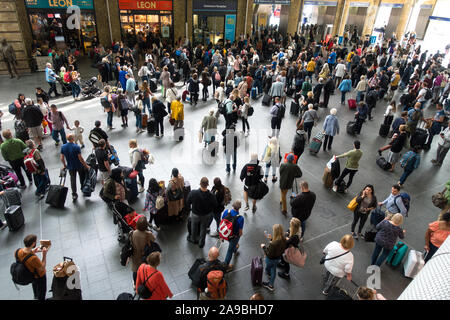 Fluggästen, die auf Informationen und Abfahrt Bahnhof KingsCross London UK Stockfoto