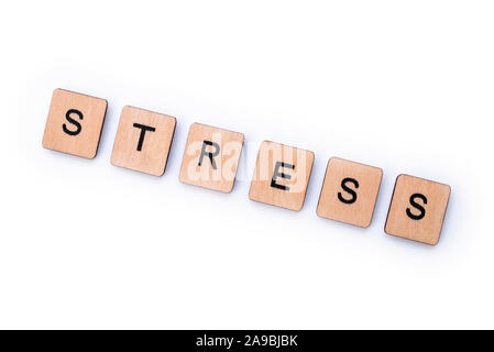 Das Wort STRESS, Dinkel mit hölzernen Buchstabensteine über einem weißen Hintergrund. Stockfoto