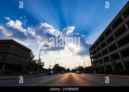 Sonnenstrahlen scheint durch Wolken an einem schönen Sommertag in einer Stadt. Stockfoto