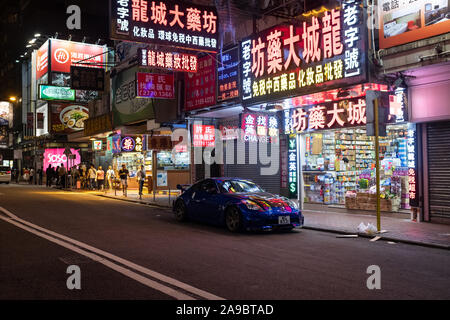 Ein Nissan GT-R sitzt unter bunten Leuchtreklamen in einer Seitenstraße von Tsim Sha Tsui in Kowloon, Hong Kong. Stockfoto