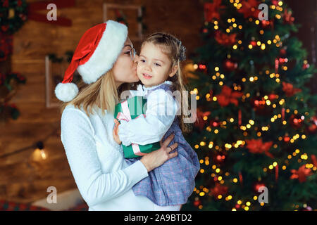 Mutter mit ihrer Tochter mit Geschenken zu Weihnachten. Stockfoto