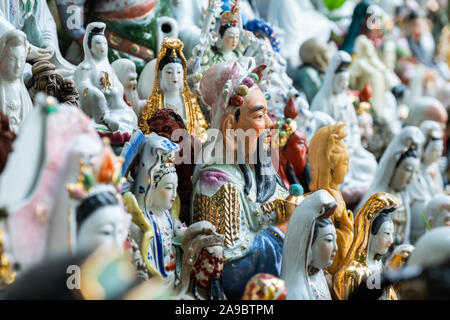 Hunderte von kleinen Statuen, die Götter der verschiedenen Religionen an einem Hügel in einem Coastal Park im Waterfall Bay, Hong Kong sitzen. Stockfoto