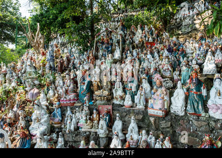 Hunderte von kleinen Statuen, die Götter der verschiedenen Religionen an einem Hügel in einem Coastal Park im Waterfall Bay, Hong Kong sitzen. Stockfoto