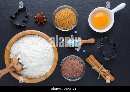 Zutaten und Küchengeräte zum Nachtisch Backen auf schwarzem Hintergrund Stockfoto
