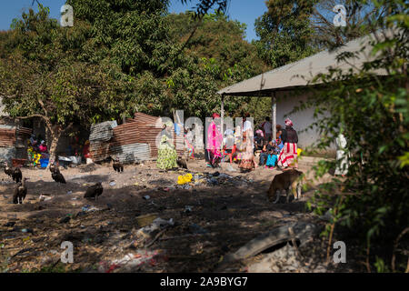 Gabu, Republik Guinea-Bissau - 11. Februar 2018: Die Menschen versammeln sich in der Nähe ein Haus in einem Slum am Rande der Stadt von Gabu, mit Schmutz in den Stree Stockfoto