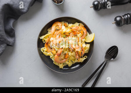 Reginette Pasta Spaghetti mit Meeresfrüchten, Krabben, Muscheln schwarz auf grau Tabelle, Ansicht von oben. Traditionelles Gericht in Italienisch. Stockfoto