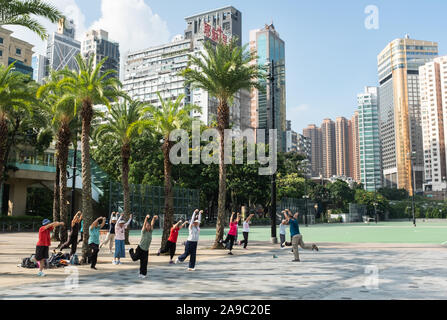 Menschen nehmen an einem Tai Chi Kurs an einem warmen Sommermorgen in Victoria Park, Central Hong Kong. Stockfoto